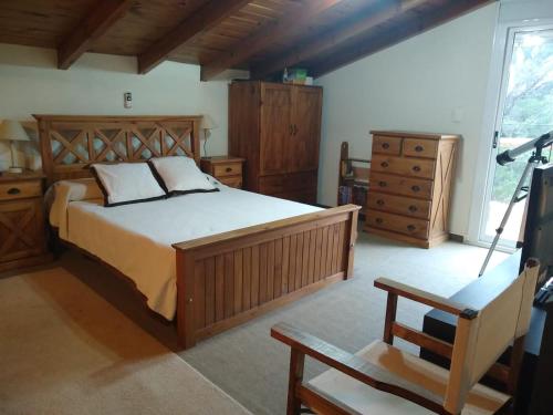 a bedroom with a large bed and wooden furniture at Ollagua casa con pileta Villa Ventana in Villa Ventana