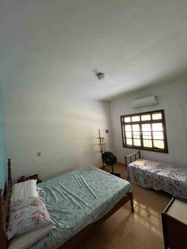 a bedroom with two beds and a window at Casa estilo sítio in Aracruz