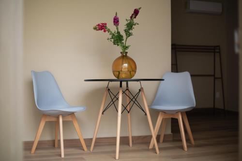 a table with two chairs and a vase with flowers on it at El Consuelo in Oaxaca City