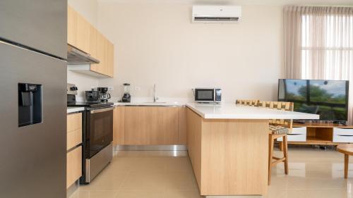 a kitchen with wooden cabinets and a white counter top at Breeze and Sunset at Playa Hermosa in Playa Hermosa