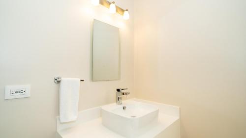 a white bathroom with a sink and a mirror at Breeze and Sunset at Playa Hermosa in Playa Hermosa