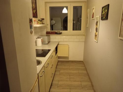 a small kitchen with a sink and a window at Cosy place with air conditioning, close to the Saturn Thermal Pools and the airport in Czeladź