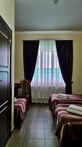 a hotel room with two beds and a window at Готель "Валерія" in Novoselytsya