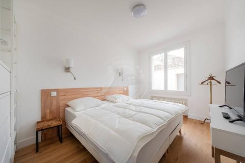a white bedroom with a bed and a desk at AS21755 - Grand P3 Vue Canal au cœur du Centre-Ville à 20m de la plage in Le Grau-du-Roi
