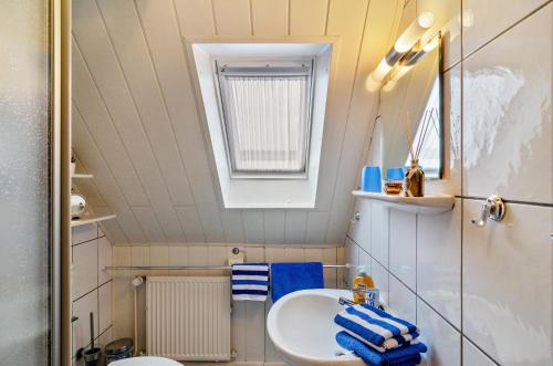 a small bathroom with a sink and a mirror at Ferienwohnung Karin in Marienhafe