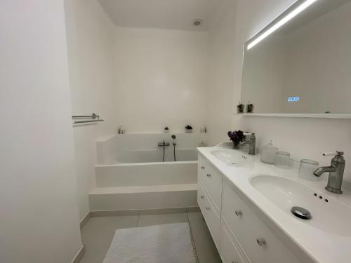 une salle de bain blanche avec une baignoire et un lavabo dans l'établissement La Naronne, à Bandol
