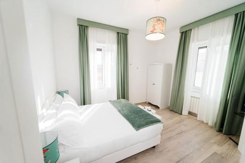 a bedroom with a white bed and green curtains at Maison Salvia in Rome