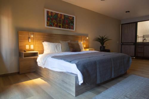 a bedroom with a large bed with a wooden headboard at El Consuelo in Oaxaca City