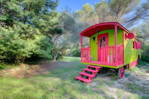 a red and green play house in a field at Mas Des Cigales et Roulotte Lambesc in Lambesc