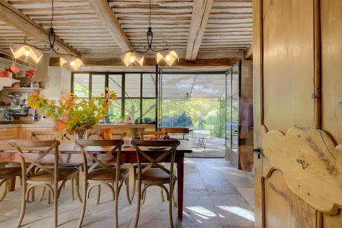a kitchen with a table and chairs and a dining room at Mas Des Cigales et Roulotte Lambesc in Lambesc