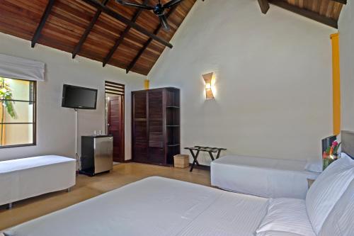 a bedroom with two beds and a flat screen tv at Hotel Amazon Bed And Breakfast in Leticia