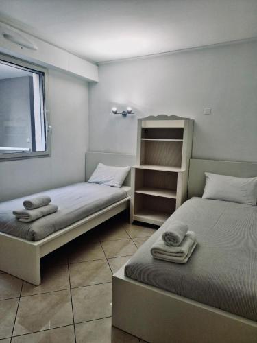 - 2 lits dans une petite chambre avec des serviettes dans l'établissement Les Jardins de Monaco, à Cap d'Ail