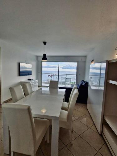 une salle à manger avec une table et des chaises blanches dans l'établissement Les Jardins de Monaco, à Cap d'Ail