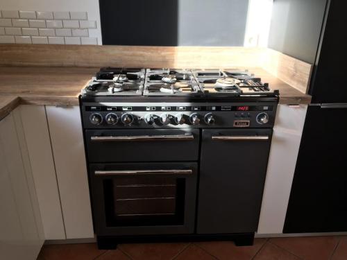 La cuisine est équipée d'un four avec plaques de cuisson noires. dans l'établissement Villa Bord de Mer Piscine, à Plouha