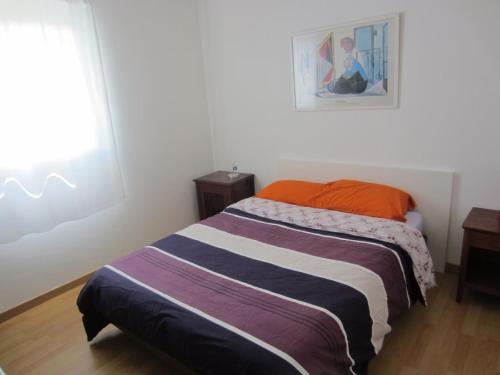 une chambre avec un lit avec une couverture rayée dans l'établissement Villa Bord de Mer Piscine, à Plouha