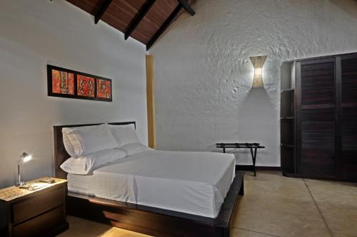 a bedroom with a white bed and a night stand at Hotel Amazon Bed And Breakfast in Leticia