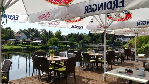 an outdoor patio with tables and chairs and umbrellas at Havelpension in Rathenow