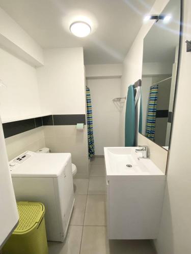 une salle de bain blanche avec un lavabo et des toilettes dans l'établissement AS21673 - Studio en rez de chaussée face au Canal, au Grau-du-Roi