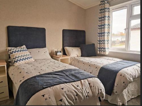 a bedroom with two beds and a window at Waterside Retreat in Wisbech