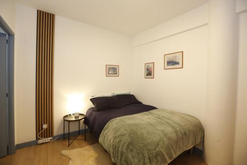une chambre avec un lit et une table de chevet dans l'établissement Charmant T2 au cœur de Marseille, à Marseille