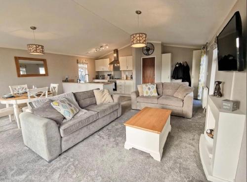a living room with two couches and a table at Waterside Retreat in Wisbech