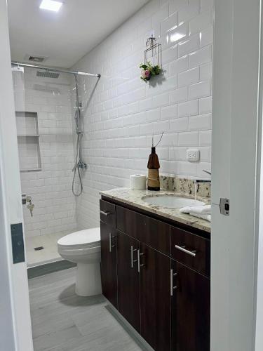 a white bathroom with a toilet and a sink at San Francisco Luxury Prestige 1 in Juticalpa