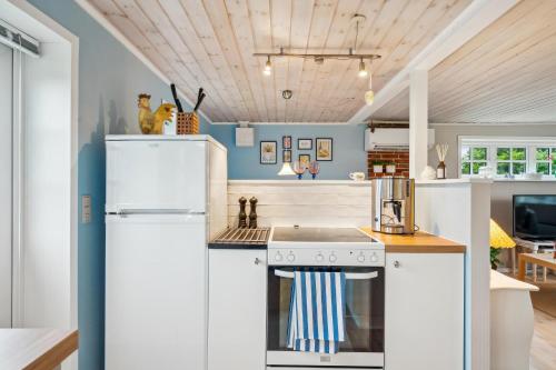 a kitchen with white appliances and blue walls at Cozy Summer House By Grenaa Beach in Grenå