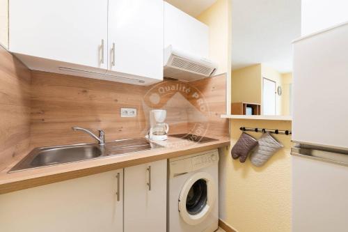 une cuisine avec un évier et une machine à laver dans l'établissement AS21600 - P2 Cabine à 200m de la plage avec parking privatif, au Grau-du-Roi