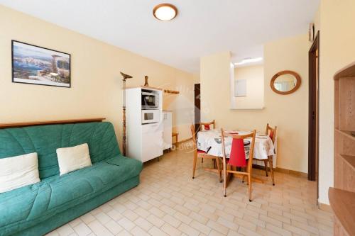 un salon avec un canapé vert et une table dans l'établissement AS21600 - P2 Cabine à 200m de la plage avec parking privatif, au Grau-du-Roi