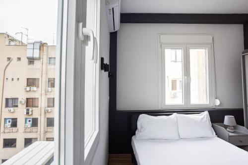 a bedroom with a white bed and a window at Thessaloniki Central Apartment 2 in Thessaloniki