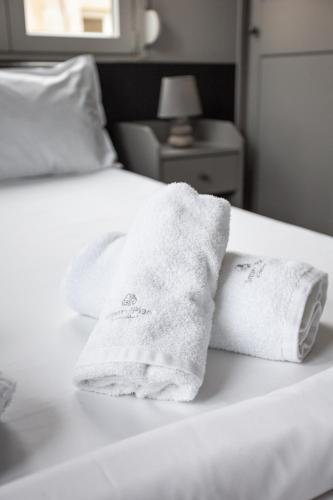 two towels are sitting on a white bed at Thessaloniki Central Apartment 2 in Thessaloniki