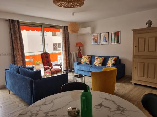 un salon avec des canapés bleus et une table dans l'établissement Magnifique T3, spacieux, lumineux et traversant, à Nice