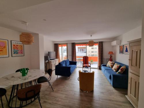 un salon avec un canapé bleu et une table dans l'établissement Magnifique T3, spacieux, lumineux et traversant, à Nice