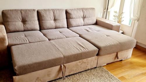 - un canapé brun dans le salon dans l'établissement Thiais large apartment near ORLY PARIS 4 à 6 personnes, à Thiais