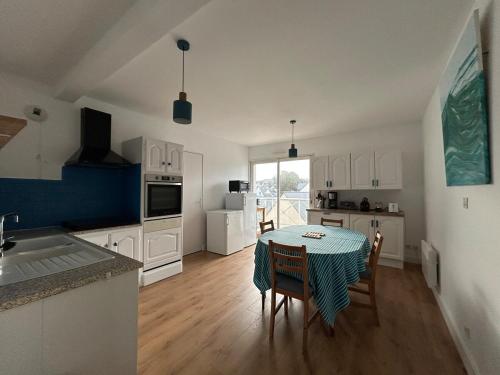a kitchen and dining room with a table and chairs at L'Evasion Marine - mer & plage de sable fin à pied in Saint-Quay-Portrieux