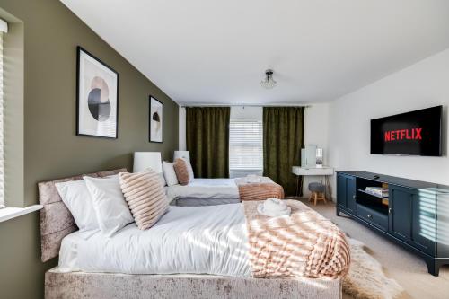 a bedroom with a bed and a couch at Stunning Detached House with Driveway Parking, Office Room, Self-Check-In, Fast WiFi and Smart TV with Sky and Netflix by Yoko Property in Milton Keynes