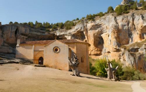 a small church in front of a mountain at El Mirador De Campumedra in Vadillo
