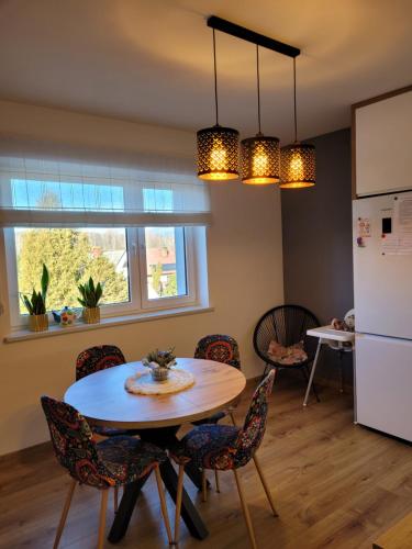 eine Küche mit Tisch und Stühlen und einem Kühlschrank in der Unterkunft Apartamencik Pod Krokusem in Rabka-Zdroj
