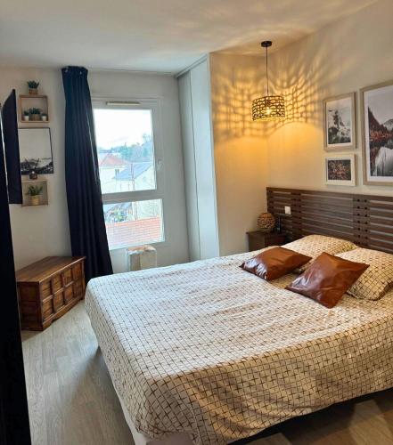 une chambre avec un grand lit et une fenêtre dans l'établissement Le Montagnard - Wifi - Clim - Chaleureux, à Lourdes