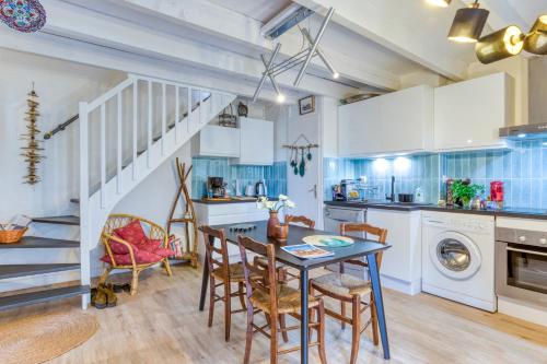a kitchen and dining room with a table and chairs at Maison pour 6 entre Vignes et Mer in Marseillan
