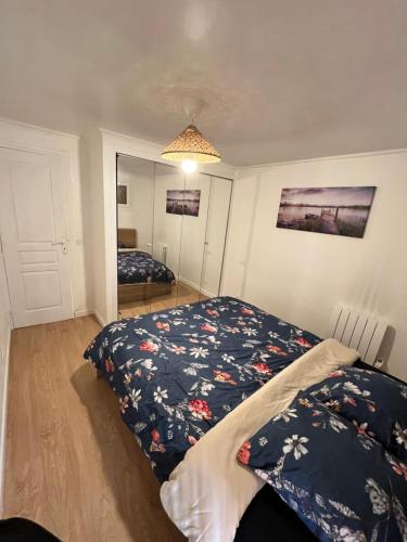 une chambre avec un lit et un miroir dans l'établissement Appartement dans petite résidence très calme, à Drancy