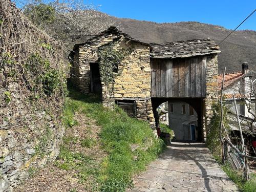 an old stone building with a wooden door and a tunnel at Rifugio di Rezzo in Rezzo