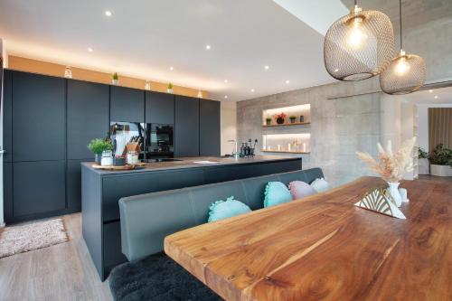 a dining room with a wooden table and a kitchen at Helle Lichtdurchflutete Wohnung in Karsau