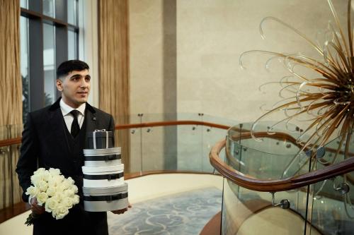 a man in a suit holding a bouquet of flowers at The St. Regis Saadiyat Island Resort, Abu Dhabi in Abu Dhabi