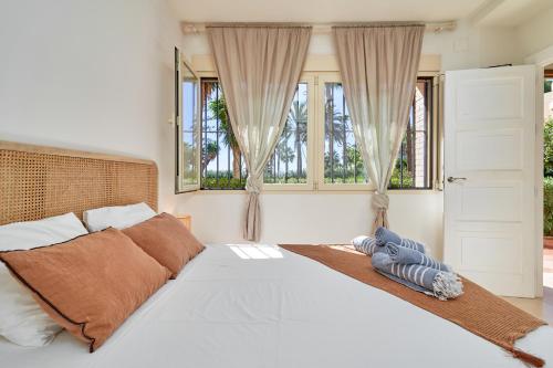a bedroom with a large white bed with windows at Rosa Náutica La Herradura in Almuñécar