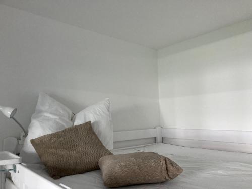 Cette chambre blanche dispose d'un lit avec un oreiller. dans l'établissement Somski Saalbach, à Saalbach-Hinterglemm