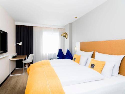 a hotel room with a large bed and a desk at Holiday Inn - the niu, Dairy Haarlem in Haarlem