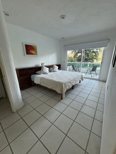 a bedroom with a bed and a large window at Acogedor depto Acapulco Diamante frente a campo de Golf Vidanta in Acapulco