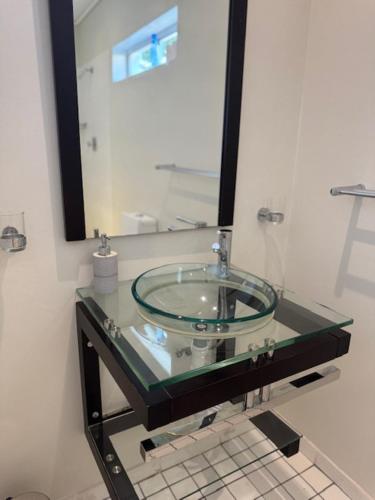 a glass sink in a bathroom with a mirror at Flyers' Lodge in Porterville
