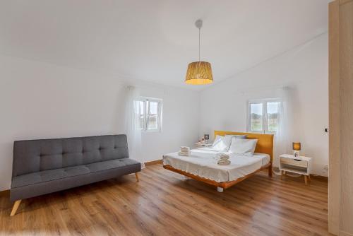 ein Schlafzimmer mit einem Bett und einer Couch in der Unterkunft Casa Maria D'Almeida in Reguengos de Monsaraz